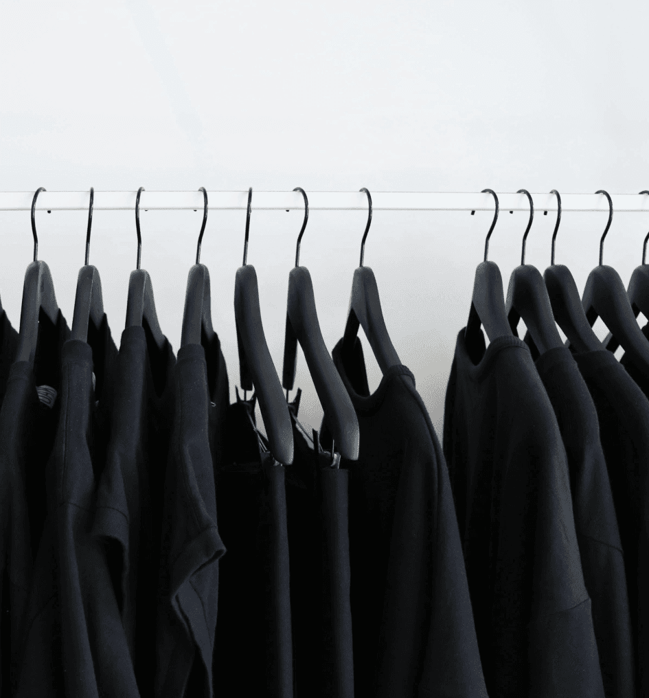 Rząd czarnych bluz na wieszakach symbolizujących zmieniające się trendy w modzie i e-commerce.